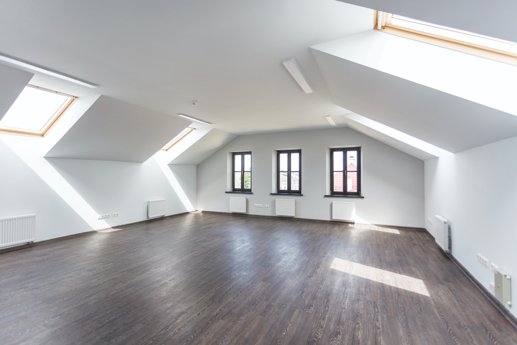 Side view of unfurnished room interior with wooden floor on roof floor, white walls